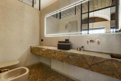 a bathroom with a sink and a toilet and a mirror at Mohala Boutique Hotel in Diso