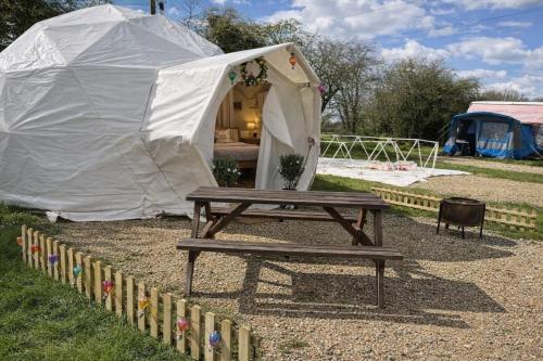 a tent with a picnic table in front of it at Pewsey Countryside Dome - Dog Friendly - Fire pit in Pewsey