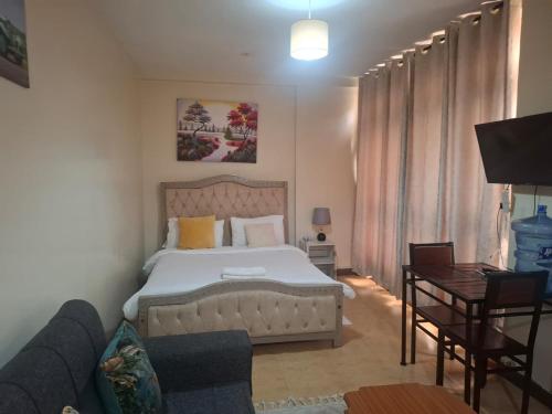 a bedroom with a bed and a couch at Executive Express Rooftop Pool suites- Ngara in Nairobi