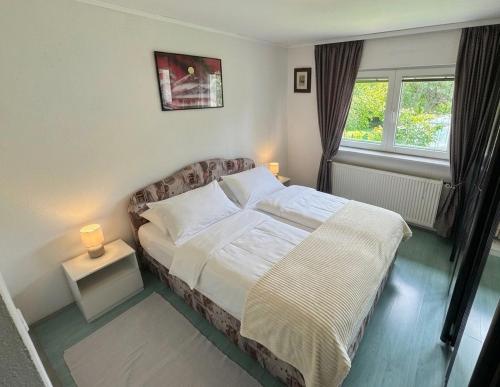 a bedroom with a bed and a window at Hava apartment in Sarajevo