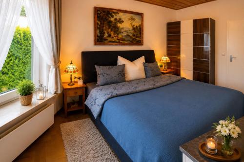 a bedroom with a blue bed and a window at Zuhause am Bach Ruhige Unterkunft für Erholungssuchende am Welterbesteig und Donauradweg in Aggsbach