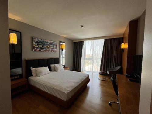 ein Hotelzimmer mit Bett und Fernseher in der Unterkunft Windyhill Hotel in Elâzığ