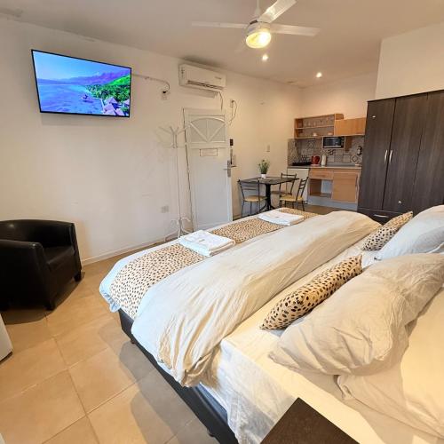 two beds in a room with a tv on the wall at G6 Monoambiente King con Cochera en Villa Ángela in Villa Ángela