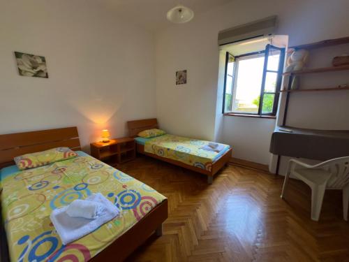 a small room with two beds and a window at Garden Vista Stone House in Kotor