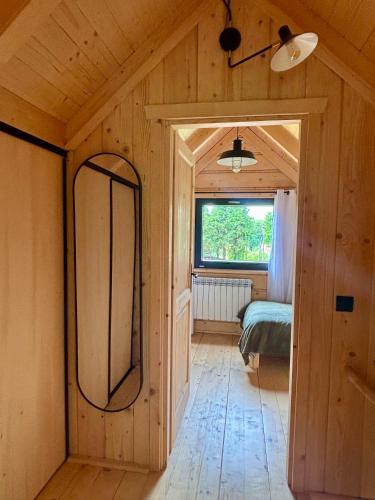 a room with a mirror and a bed in it at Chata u Drwala Święta Lipka in Święta Lipka