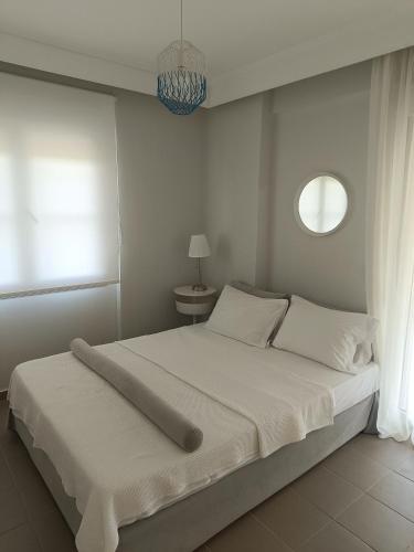 a bedroom with a large white bed with a window at OLIVE & SEA in Nea Moudania