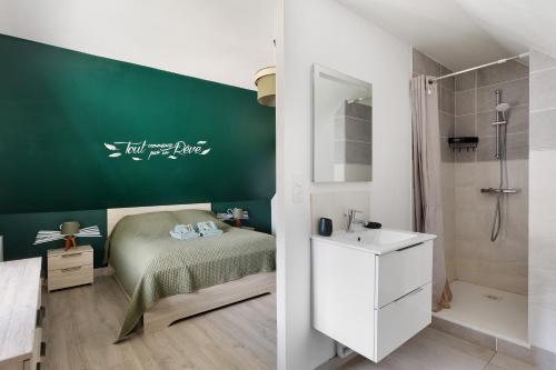 a bedroom with a bed and a shower and a sink at Gîte Le Rabelais in Thésée