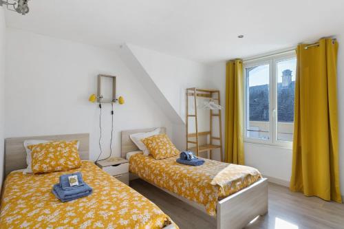 a bedroom with two beds and a window at Gîte Le Rabelais in Thésée