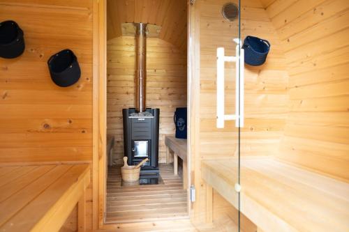 a sauna with a stove in a wooden cabin at Chalet Au in Fischen