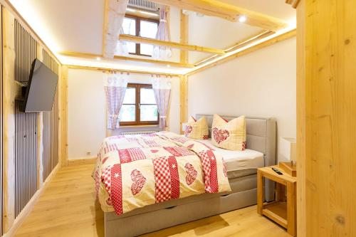 a small bedroom with a bed and a television at Chalet Au in Fischen