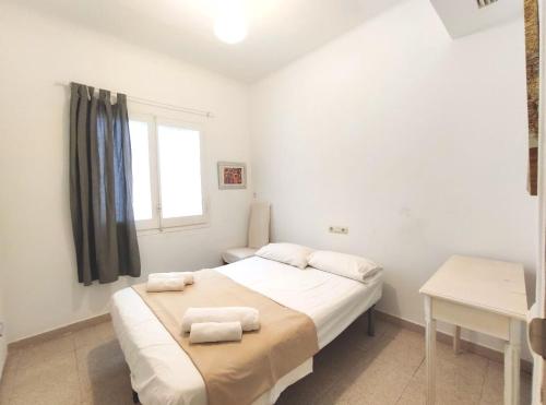 a bedroom with a bed with towels on it at Maribeach Sitges in Sitges