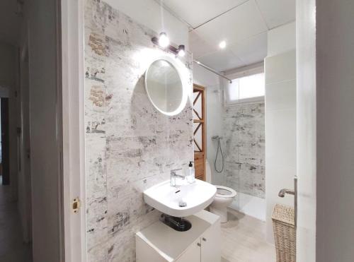 a white bathroom with a sink and a mirror at Maribeach Sitges in Sitges