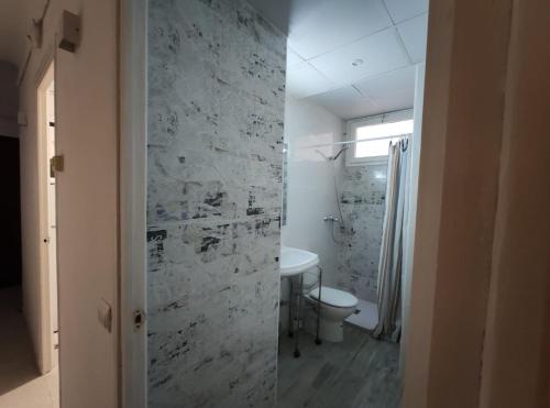 a bathroom with a white toilet and a sink at Maribeach2 Sitges in Sitges