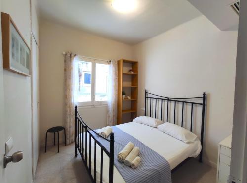 a bedroom with a black bed and a window at Maribeach2 Sitges in Sitges