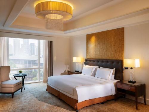 a bedroom with a large bed and a large window at Fairmont Makati in Manila