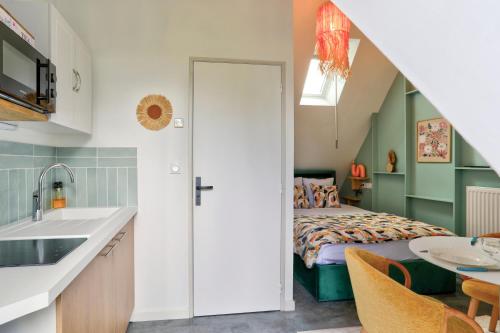 a kitchen and a bedroom with a bed at Gîte du Merlin in Plumergat