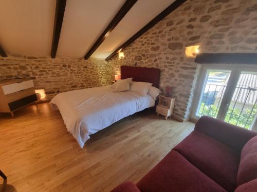 a bedroom with a large bed and a couch at L'Oustau de Maître Potager in Valréas