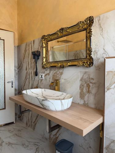 a bathroom with a sink and a mirror at PRINCIPE ROOMS in Rodigo