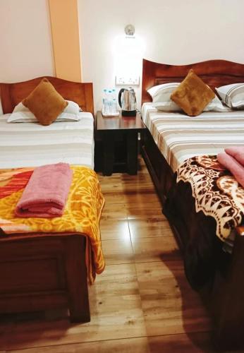 a hotel room with two beds and a telephone at Arara ibt homestay in Cherrapunji