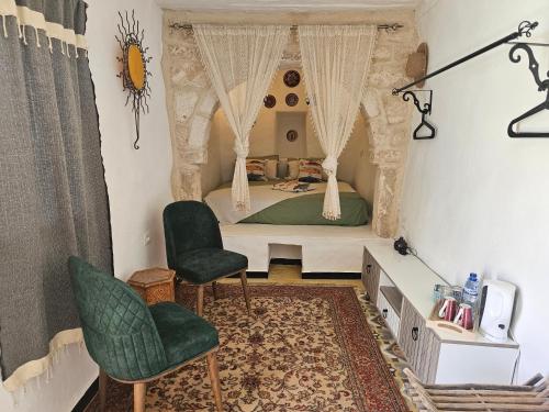 a bedroom with a bed and two chairs at Dar Chauphaly in Houmt Souk