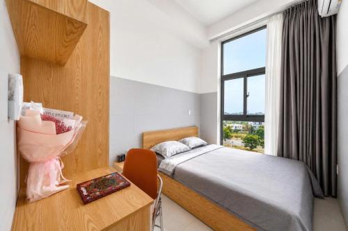 a bedroom with a bed and a desk and a window at Savia Home in Danang
