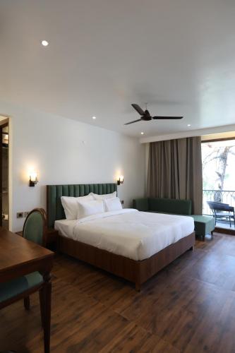 a bedroom with a large bed and a table at Ventus Pines in Kasauli