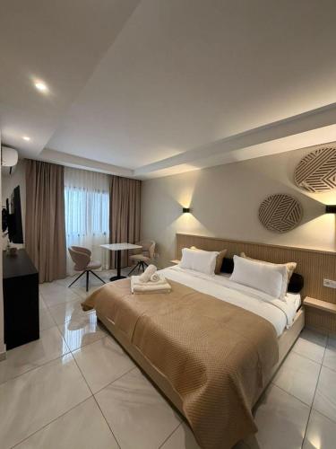ein Hotelzimmer mit einem großen Bett und einem Tisch in der Unterkunft Kadiss Hotel in Dakar