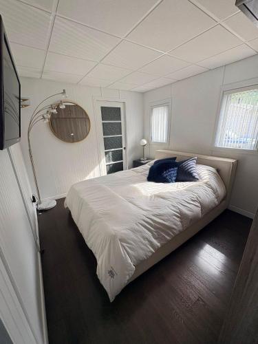 ein Schlafzimmer mit einem großen weißen Bett und blauen Kissen in der Unterkunft Azura in Roberval