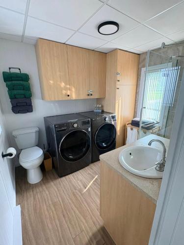 ein Badezimmer mit Waschmaschine und Waschbecken in der Unterkunft Azura in Roberval