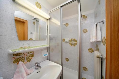 a white bathroom with a sink and a shower at Haus Bernhard in Schenna