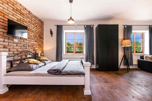 a bedroom with a bed and a brick wall at Resort Biskupský Dvůr in Višňová