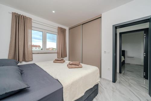 a bedroom with a bed with two towels on it at Villa Lukas in Nin