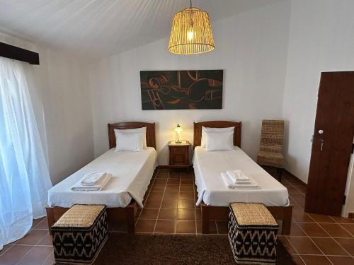 a room with two beds and a chandelier at Casa Grande do Monte in Mértola
