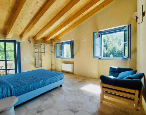 a bedroom with a bed and a couch and windows at Villa Gioia Agriturismo in Monterosso al Mare