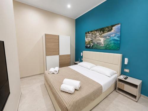 a bedroom with a large bed with towels on it at Maison Sicilienne in Turin
