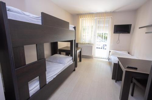 a bedroom with two bunk beds and a desk at Fürdőkerti Ifjúsági Szálló in Hajdúböszörmény