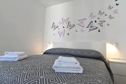 a bedroom with a bed with butterflies on the wall at Apartments and Rooms Oliva in Cres