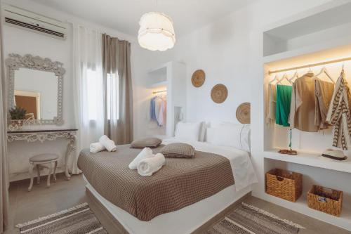 a white bedroom with a bed with towels on it at Bonatsa House in Agios Georgios