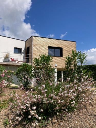 a brick house with some flowers in front of it at Superbe T2 "Les Enclos" - Vue panoramique, jardin à 5 mn des plages in La Bernerie-en-Retz