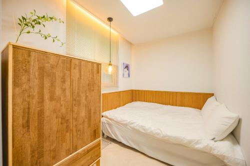 a bedroom with a bed and a wooden cabinet at Eunpyeong St Mary's Hospital Yeonsinnae Station 3R3B Bukhansan 인사동 Namsan DDP 동대문 명동 Itaewon 20 mins in Seoul