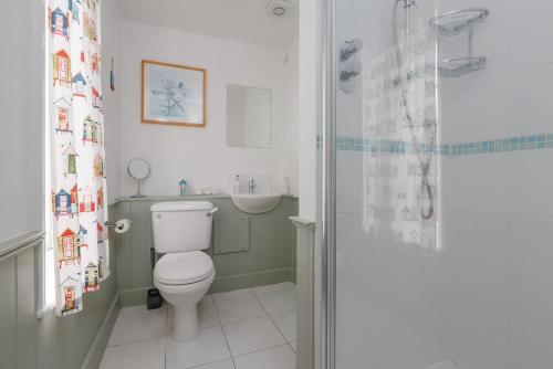 a bathroom with a toilet and a sink and a shower at Westport Cottage in Wareham