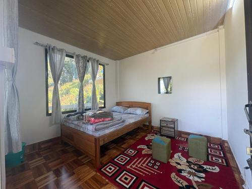a bedroom with a bed and a window at Bikash Homestay in Mangpu