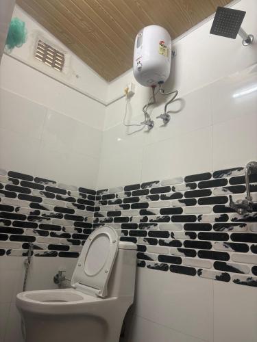 a bathroom with a toilet and a camera on the wall at Bikash Homestay in Mangpu