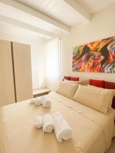 a large white bed with two towels on it at Domoo Boutique Hotel in Torraca