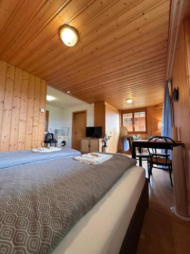 a bedroom with two beds and a table in it at CapoBnB, Montainview, Terrace in Aeschi bei Spiez