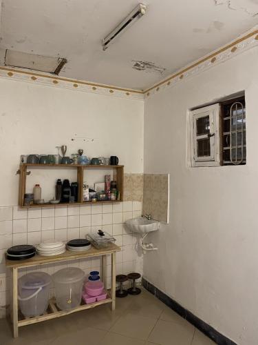 a bathroom with a sink and a shelf with dishes at Belalonte House, Iringa in Iringa