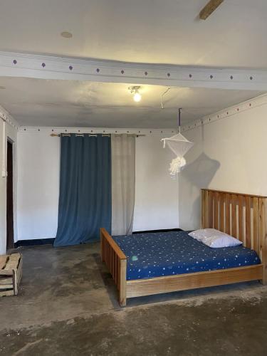 a bedroom with a bed with a blue bedsheet at Belalonte House, Iringa in Iringa