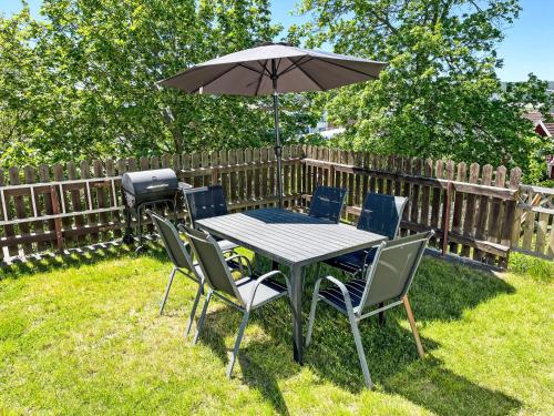 a table and chairs with an umbrella and a grill at Apartment Stadsro by Interhome in Vimmerby