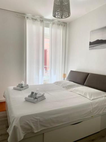 a white bedroom with a large bed with white sheets at Montebello in Bellinzona