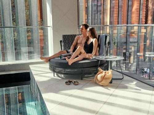 a man and a woman sitting in a chair on a building at Movenpick Hotel Melbourne On Spencer in Melbourne